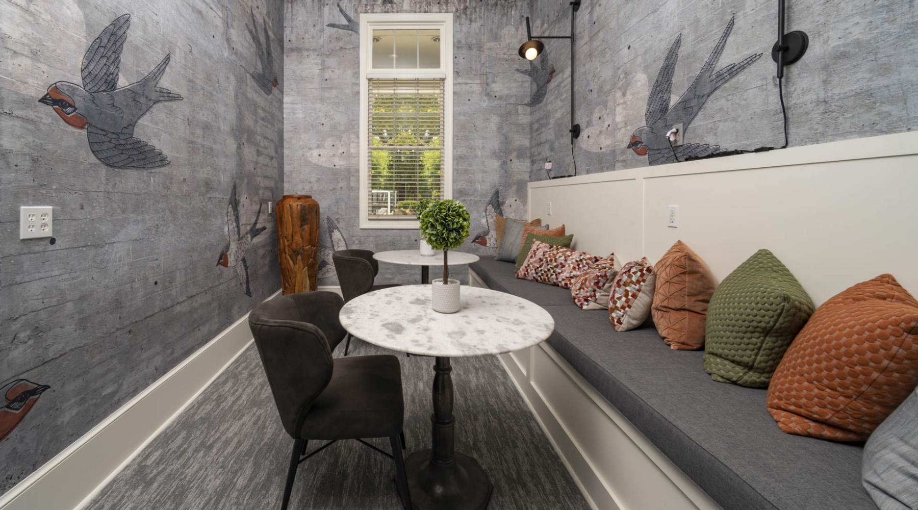 a seating area with tables pillows and a window