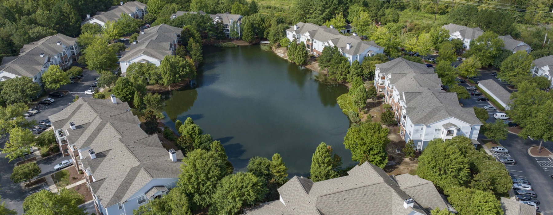 body of water surrounded by trees and buildings